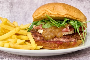 Hamburger with bacon, arugula and french fries