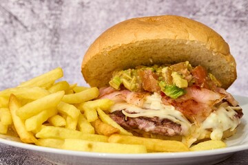 Hamburger with bacon, arugula and french fries