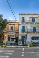 Aging building adorned with multiple balconies stands on a street corner in Mdina Old City Fortress