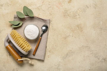Composition with bowl of baking soda, cleaning brush, napkin and eucalyptus branch on grunge...