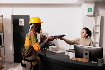 Storehouse supervisor discussing order shipping details with african american employee, preparing customer packages in storage room. Diverse team working at goods inventory in warehouse