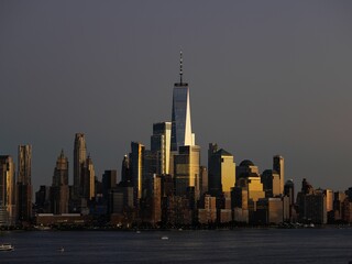 Fototapeta premium Manhattan Cityscape surrounded by a river in the evening in New York City