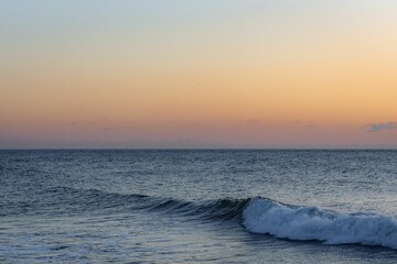 Captivating image of a calming sunset with a majestic ocean wave in the foreground