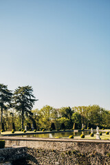 Fototapeta premium Vertical shot of the garden of the Chateau de Breteuil in Choisel, France in blue sky background