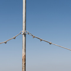 um cabo de aço e um poste sob um céu azul típico de outono