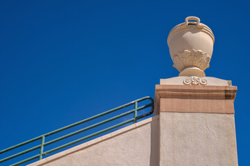Grecian Urn on top of an Inclined Wall.