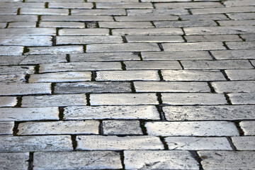 Obraz premium Stara brukowana droga, zabytkowa ułożona z marmuru w kwadraty.