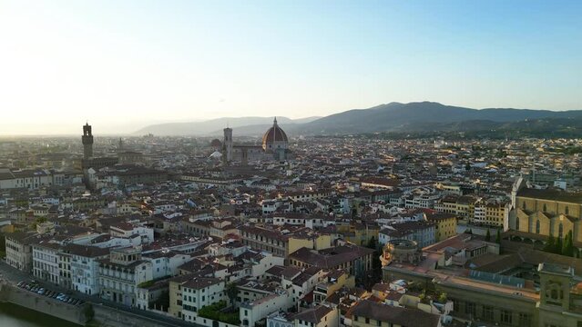 Establishing aerial view shot of Florence city skyline, sunset golden hour, historic city center, Cathedral of Saint Mary of the Flower, Tuscany, Italy