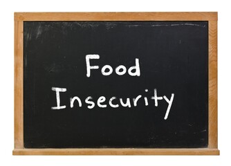 Obraz premium Food Insecurity written in white chalk on a black chalkboard isolated on white