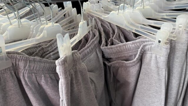 Gray Jogging Pants with Elastic Waistband on a Hanger in a Fashion Store