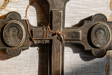 A small cross for the baptism of a child on the background of an old Holy large metal Cross.