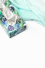 Box with tissues and scarf on white background