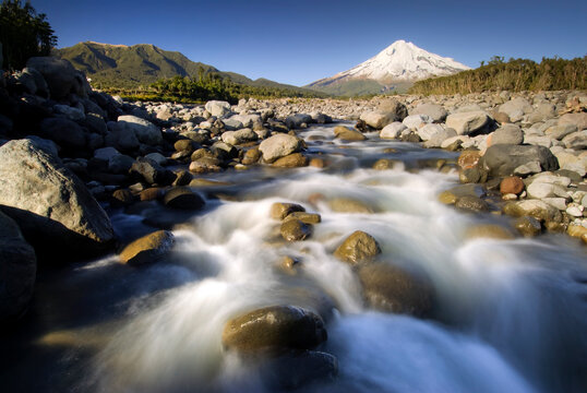 Mt. Taranaki with large boulders in raging river, New Zealand