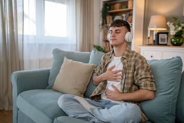 One teen man doing guided meditation yoga self care practice at home - obrazy, fototapety, plakaty