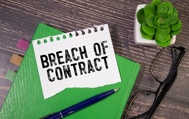 BREACH OF CONTRACT. text in notepad next to glasses on white background.
