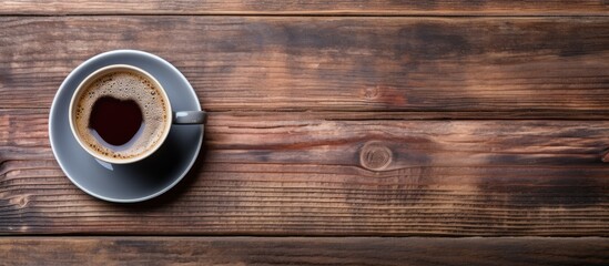Top view of a coffee cup on a wooden table - obrazy, fototapety, plakaty