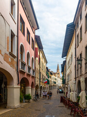 View of typical street with walking people in historical center of Pordenone in sunny autumn day, Italy