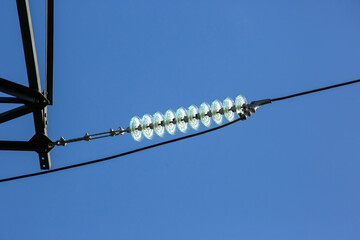 High voltage tower with electrical voltage wires isolates close-up against the background of...