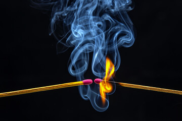 Fire and smoke. Burning and smoking match on a black background. Heat and light from fire flame