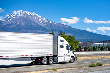 Mine carrier long hauler big rig semi truck transporting cargo in refrigerator semi trailer moving...