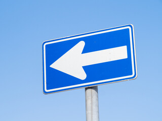 道路標識(規制標識)「一方通行」と、青空。  © midori_stock