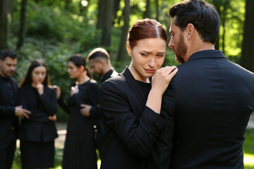 Obraz premium Sad people in black clothes mourning outdoors. Funeral ceremony