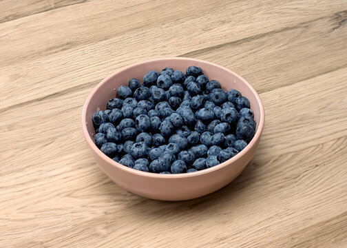 Blueberries in a bowl on a wooden background. Edited with Generative AI tools
