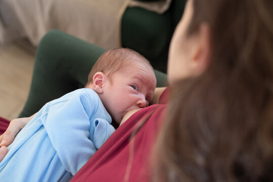 Mother breastfeeding newborn baby looking at her
