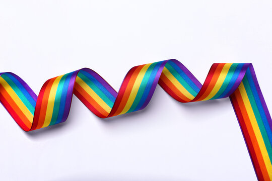 Rainbow ribbon on white background, top view. LGBT pride
