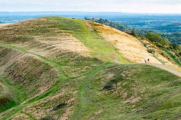 Hill walkers stroll down from Herefordshire Beacon,heading south along British Camp hill...