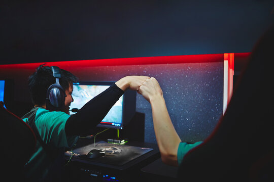 eSportsカフェでガッツポーズをする男性プレイヤーチーム