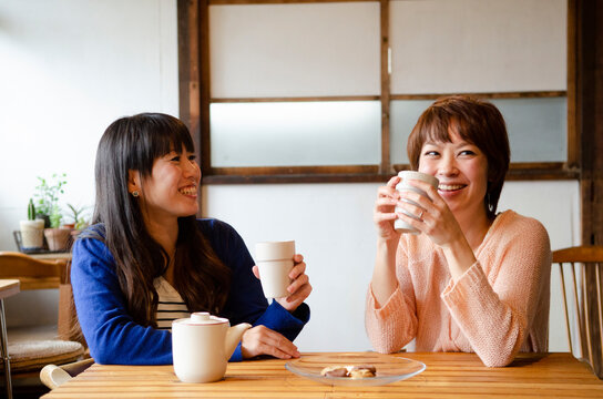 お茶を飲みながら笑っている女性2人