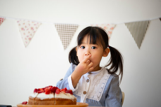 ケーキのいちごを食べている女の子