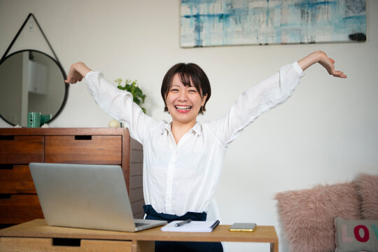パソコンの前で喜んでる女性