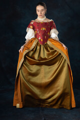 Woman wearing a Renaissance, Tudor, Georgian, or high fantasy costume with a red embroidered bodice and a pearl choker