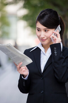 スマホで電話するスーツの女性