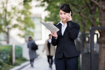スマホで電話するスーツの女性