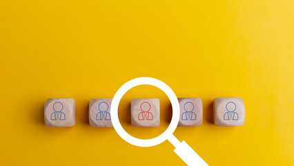 Searching for a new job concept. Magnifying glass and wooden cube with people icons. Online recruitment application specialist search service concept