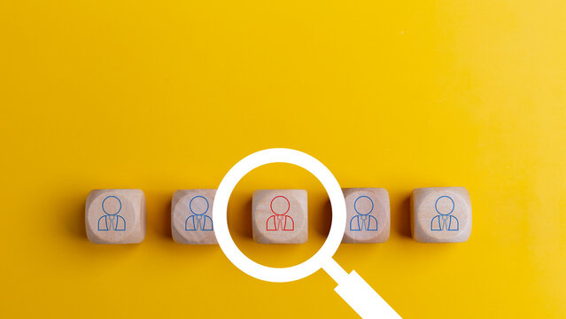 Searching for a new job concept. Magnifying glass and wooden cube with people icons. Online recruitment application specialist search service concept