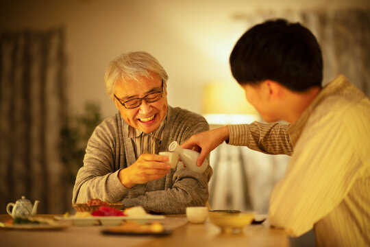 日本酒で晩酌をする親子