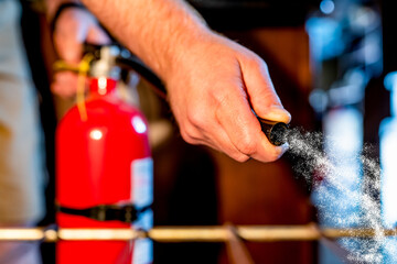 View from inside an oven with selective focus on a extinguisher being aimed at the fire. 