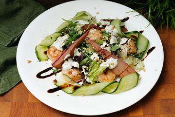 Green salad with drunken pear and shrimp, nuts, cucumber slices with yogurt sauce