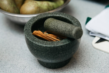 Mortar and pestle with spices on a kitchen table. Ingredients for culinary class.