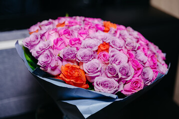 Bouquet of pink and purple roses in a vase. The delicate petals of these roses create a stunning arrangement that adds a touch of elegance to any room.