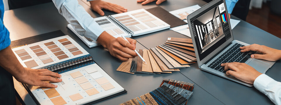 Group of interior architect designer team at table choosing various mood board samples with architecture software on laptop screen. Modern renovation and interior material selection concept. Insight