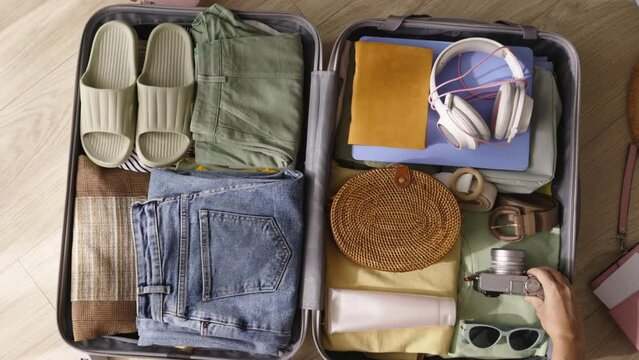 Putting condoms in trip travel suitcase. Woman puts clothes in suitcase female hands stuff pair of condoms into back pocket jeans. Health care prevention sexually transmitted diseases contraception