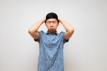 Asian man blue shirt holding head feels doubt and dizzy with working isolated