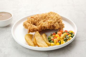 Crispy Chicken Steak with french fries and vegetables. 
