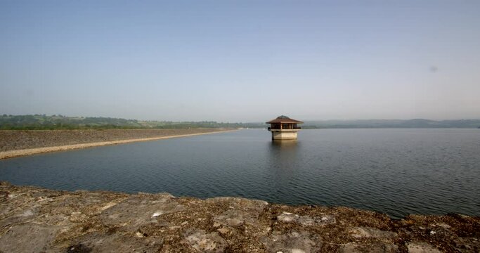 Wide shot of Carsington Water with the Water Valve Tower, Draw Off Tower and the dam to the left