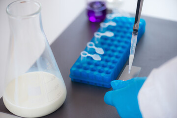 An expert assesses milk quality in a laboratory, using test tubes for analysis.
